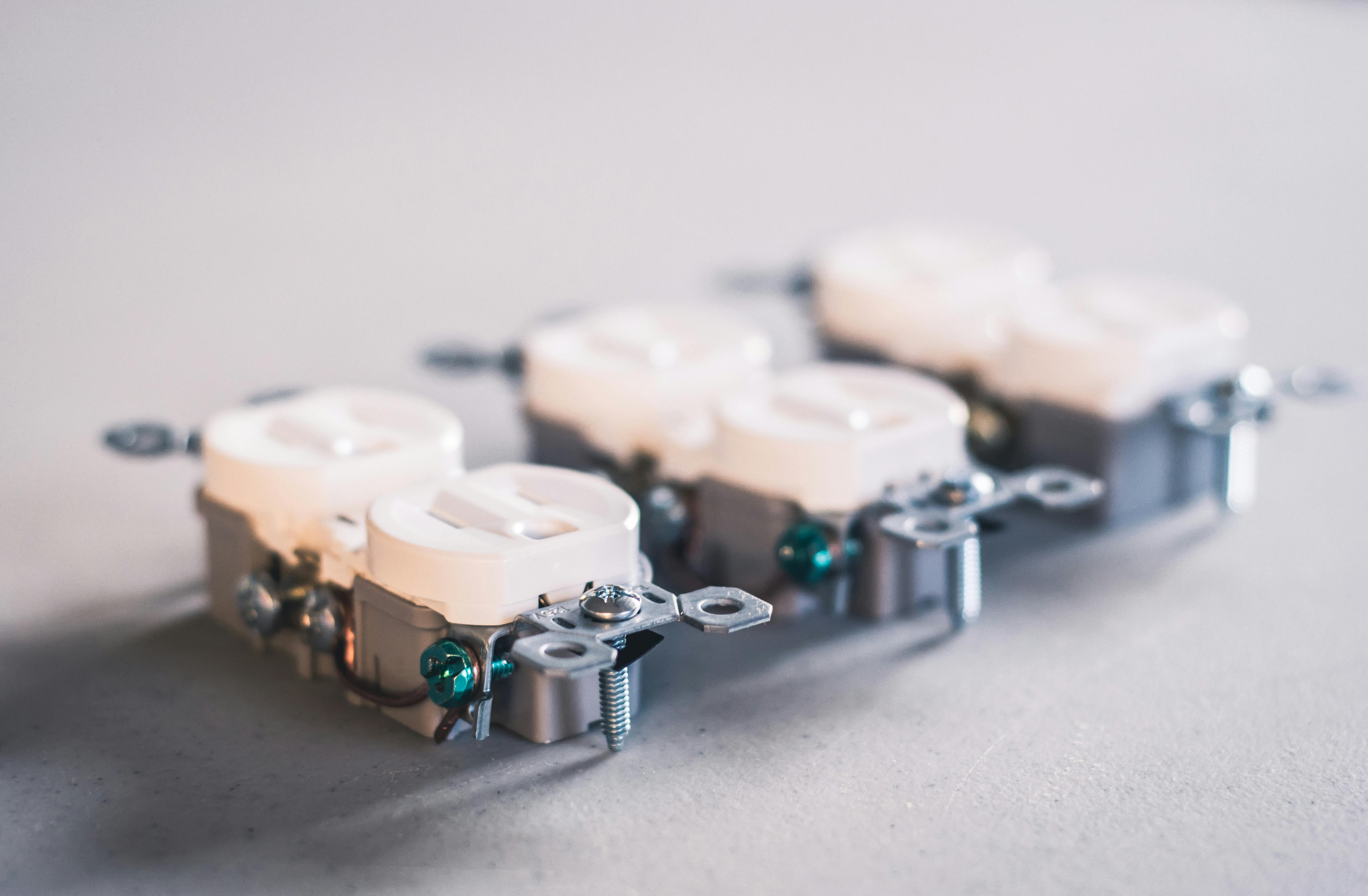 Professional electrician working on electrical panel with proper tools and safety equipment